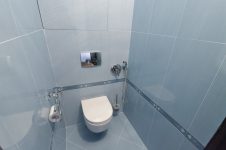 Светло-голубая плитка в туалете, подвесной унитаз со скрытым сливным механизмом