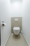 Подвесной унитаз в туалете, белые стены