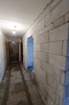 Заново выстроенные перегородки и залитые полы в коридоре