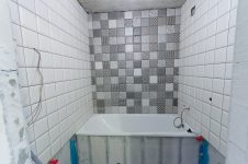 Ванная - три стены белая плитка, над ванной стена из черно-белых декоров