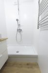 Душевая лейка и смеситель установлены по центру ванной комнаты