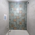 Укладка плитки с декорами над ванной