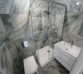 На стенах уложен керамогранит LCM Illusion Flow 60x60